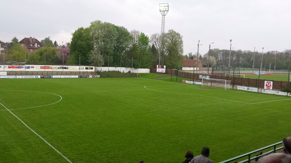 Stade de football amateur, pelouse et panneaux